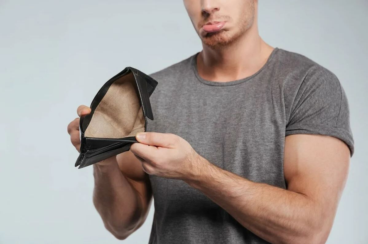 sad young man showing an empty wallet